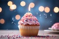 Birthday cupcake with burning candle, closeup, light background