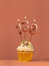 Birthday cupcake with candle number 139 - Coral fusion background Royalty Free Stock Photo