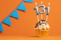 Birthday cupcake with candle number 131 - Orange background