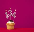 Birthday cupcake with candle number 134 - Rhodamine Red foamy background