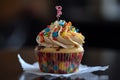 Birthday cupcake with a candle on top on a dark background, A Happy birthday cupcake with so many sweet toppings and candle, AI