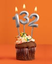 Number 132 candle - Birthday cupcake on orange background Royalty Free Stock Photo