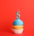 Birthday cupcake with number five candle on red Royalty Free Stock Photo