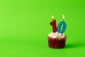 Birthday cupcake with number ten candles against neon green background Royalty Free Stock Photo