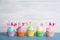 Birthday cupcakes with burning candles on blue wooden table Royalty Free Stock Photo