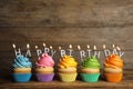 Birthday cupcakes with burning candles on table against background. Space for text Royalty Free Stock Photo