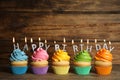 Birthday cupcakes with burning candles on table against background. Space for text Royalty Free Stock Photo