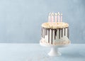 Birthday Drip Cake lots of pink candles with chocolate ganache and sprinkles on a light background, banner. Copy space. Royalty Free Stock Photo