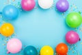 Birthday frame of colorful balloons and confetti on blue table top view. Flat lay style. Royalty Free Stock Photo
