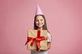 Birthday gift. Portrait excited girl in cap and big gift Royalty Free Stock Photo