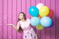 Birthday girl with balloons and soap bubbles against rose metal wall. Royalty Free Stock Photo