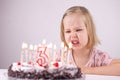 Birthday girl, unhappy with cake, angry face, caucasian toddler girl, cake Royalty Free Stock Photo