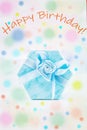 Birthday greeting card. Blue gift box on a festive colored background