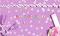 Birthday greeting card. Colorful Happy Birthday candles and confetti on purple background, top view. Festive or party background Royalty Free Stock Photo