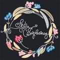 Birthday greeting in Spanish. Text says Happy Birthday. Wreath and hand lettering on black backgound Royalty Free Stock Photo