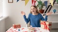 Birthday happy laughing girl 20s spreads her hands communicating to the camera via video communication while sitting at Royalty Free Stock Photo