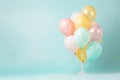 Birthday helium balloon bunch in gold and pink colours on light teal background