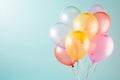 Birthday helium balloon bunch in pink blue and yellow colours on teal background