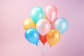 Birthday helium balloon bunch in yellow blue and red colours on pink background Royalty Free Stock Photo