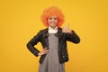 Birthday kids party. Funny kid in curly clown wig isolated on yellow background. Happy girl face, positive and smiling Royalty Free Stock Photo