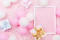 Birthday mockup with frame, gift box, pastel balloons and confetti on pink table top view. Flat lay composition. Royalty Free Stock Photo