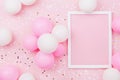 Birthday mockup with frame, pastel balloons and confetti on pink table top view. Flat lay composition. Royalty Free Stock Photo