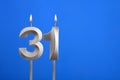 Birthday number 31 - Candle lit on blue background