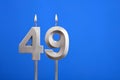 Birthday number 49 - Candle lit on blue background