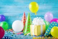 Birthday party background with gift or present box, colorful balloons, confetti, carnival cap and streamer. Holiday supplies Royalty Free Stock Photo