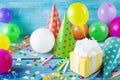 Birthday party background with gift or present box, colorful balloons, confetti, carnival cap and streamer. Holiday supplies Royalty Free Stock Photo