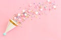 Birthday party background with hats and colorful candies over pastel pink background. Top view Royalty Free Stock Photo