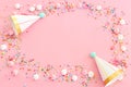 Birthday party background with hats and colorful candies over pastel pink background. Top view Royalty Free Stock Photo