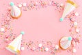 Birthday party background with hats and colorful candies over pastel pink background. Top view Royalty Free Stock Photo