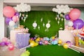 Birthday party concept, decorations for sweet party. Huge number one, table with sweets and desserts, cloud from balloons and ice- Royalty Free Stock Photo