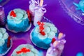 Birthday party concept. Table for kids with cupcakes with blue and red top and decored items in bright blue and purple colors.