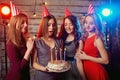 Birthday party girlfriends. Women light candles on the cake with Royalty Free Stock Photo