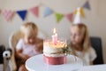 Birthday party at home. Happy little caucasian girl and cute baby with positive emotion on face celebrating first Royalty Free Stock Photo