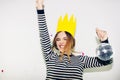 Birthday party, new year carnival. Young smiling woman on white background celebrating brightful event, wears stripped Royalty Free Stock Photo