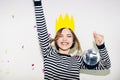 Birthday party, new year carnival. Young smiling woman on white background celebrating brightful event, wears stripped