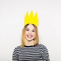 Birthday party, new year carnival. Young smiling woman on white background celebrating brightful event, wears stripped Royalty Free Stock Photo