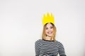 Birthday party, new year carnival. Young smiling woman on white background celebrating brightful event, wears stripped Royalty Free Stock Photo