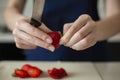 Birthday. Strawberry for cake decorating. fresh fruits. young woman slices a strawberry. Royalty Free Stock Photo