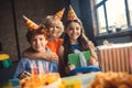 Three friends in bday hats looking cheerful