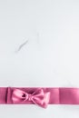 Pink silk ribbon and bow on marble background, girl baby shower present and glamour fashion gift decor for luxury beauty brand, Royalty Free Stock Photo