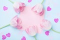 Birthday or wedding mockup with pink paper list, hearts and tulip flowers on blue background top view. Beautiful woman day card. Royalty Free Stock Photo