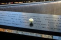 Birthday white rose near name of the victim engraved on bronze parapet of 9/11 Memorial at World Trade Center - New York, USA