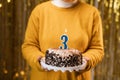 Birthday 3. Woman holding birthday cake with burning candles number 3 against decorated background, close up. Celebrates