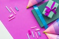 Birthday wrapped gifts and party hats on purple background top view copyspace