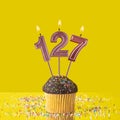 Birthday on a yellow background - Number 127 candle Royalty Free Stock Photo