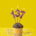 Birthday on a yellow background - Number 137 candle Royalty Free Stock Photo